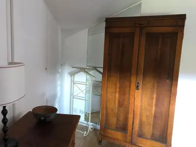 a wooden cabinet in a room with a table at Walking distance from Via Veneto in Rome