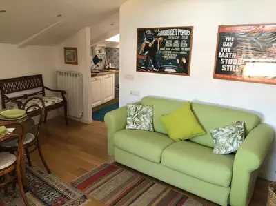 a living room with a green couch and a kitchen at Walking distance from Via Veneto in Rome