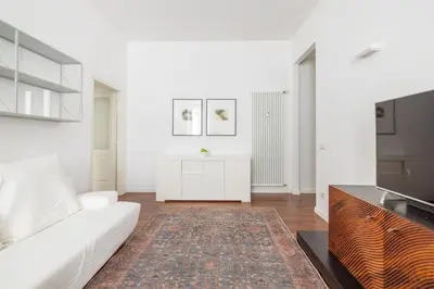 a white living room with a white couch and a rug at 3BR Comfort Apartment in Rome in Rome