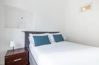 a bedroom with a white bed with blue pillows at 3BR Comfort Apartment in Rome in Rome