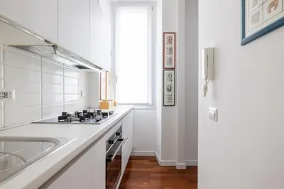 a white kitchen with a sink and a refrigerator at 3BR Comfort Apartment in Rome in Rome