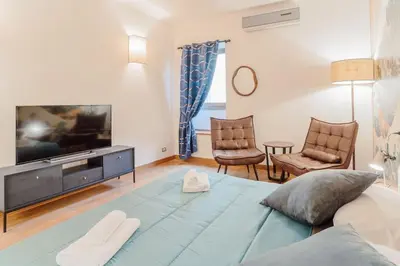 a living room with a large blue bed and a tv at La Grande Onda (Trastevere) in Rome