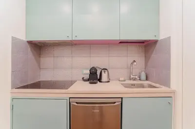 a kitchen and a bedroom with a bed and a table at La Grande Onda (Trastevere) in Rome