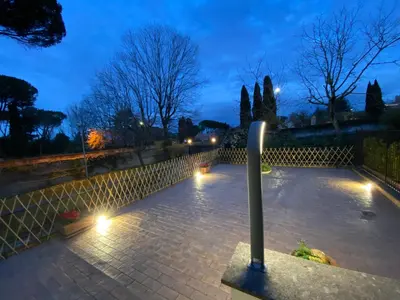 a courtyard at night with lights on a fence at Camilluccia Dream Apartment in Rome