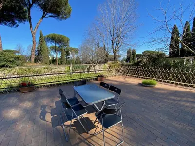 a patio with a table and chairs and a fence at Camilluccia Dream Apartment in Rome
