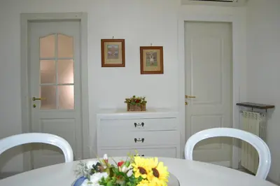 a white dining room with a table and two chairs at Perla Vaticana in Rome