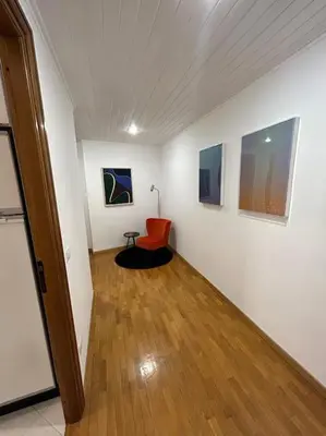 a room with a chair and paintings on the wall at Trastevere Monteverde Velia House in Rome