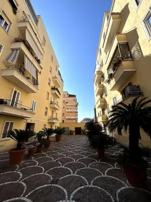 a courtyard with potted plants in front of buildings at Trastevere Monteverde Velia House in Rome