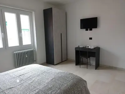 a bedroom with a bed and a desk and a television at Domus Gianicolense in Rome