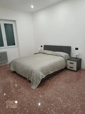 a bedroom with a bed and a night stand and a window at Domus Gianicolense in Rome