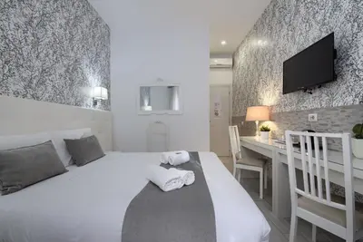 a bedroom with a bed and a desk and a television at Vatican's Roof in Rome