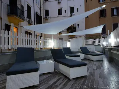 a rooftop patio with chairs and a white fence at Vatican's Roof in Rome