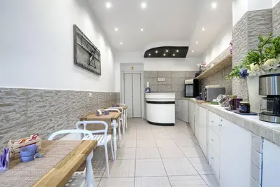 a kitchen with white counters and tables and chairs at Vatican's Roof in Rome