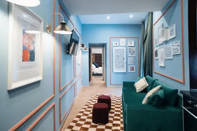 a living room with blue walls and a green couch at Victorian House, Rome Center in Rome