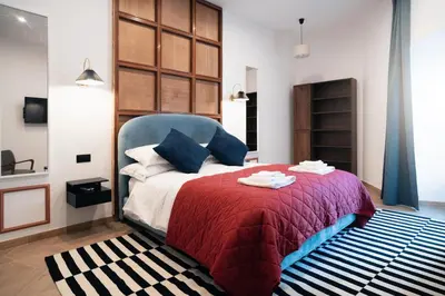 a bedroom with a bed with a red blanket at Victorian House, Rome Center in Rome