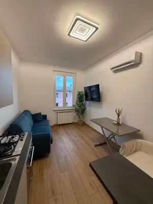 a living room with a blue couch and a table at San Lorenzo House in Rome