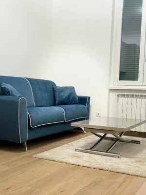 a blue couch and a coffee table in a living room at San Lorenzo House in Rome