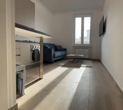 a living room with a blue couch and a table at San Lorenzo House in Rome