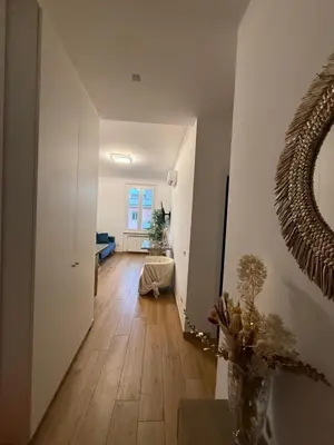a room with a hallway with a mirror and wood floors at San Lorenzo House in Rome