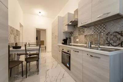 a kitchen with a sink and a table with chairs at TERMINI HOLIDAY in Rome