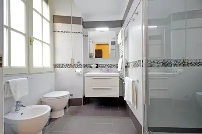 a bedroom with a bed and a desk and a chair at CASA GIULIANA - 3BR 2BATH, 2nd floor historic mansion with lift & doorman, chic, family friendly with baby equipment, 600 meters from Vatican & Ottaviano metro, quietest area of P R A T I wealthy, secure, accessible district - Guest care in 4 languages in Rome