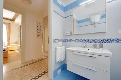 a book sitting on a white table with a chair at CASA GIULIANA - 3BR 2BATH, 2nd floor historic mansion with lift & doorman, chic, family friendly with baby equipment, 600 meters from Vatican & Ottaviano metro, quietest area of P R A T I wealthy, secure, accessible district - Guest care in 4 languages in Rome