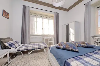 a hallway with a blue and white kitchen with a door at CASA GIULIANA - 3BR 2BATH, 2nd floor historic mansion with lift & doorman, chic, family friendly with baby equipment, 600 meters from Vatican & Ottaviano metro, quietest area of P R A T I wealthy, secure, accessible district - Guest care in 4 languages in Rome