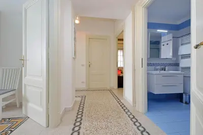 a kitchen counter with cups and dishes on shelves at CASA GIULIANA - 3BR 2BATH, 2nd floor historic mansion with lift & doorman, chic, family friendly with baby equipment, 600 meters from Vatican & Ottaviano metro, quietest area of P R A T I wealthy, secure, accessible district - Guest care in 4 languages in Rome
