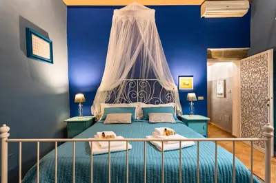a blue bedroom with a bed with a canopy at Rome as you feel - Vicolo delle Grotte in Rome