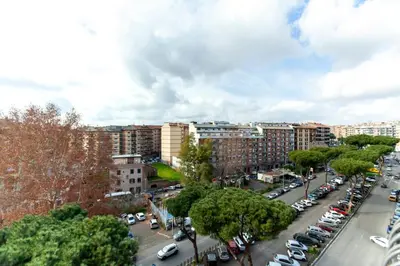 a city street with cars parked in a parking lot at Appia Nuova Lucrezia Apartment in Rome