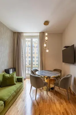 a living room with a green couch and a table at Residenza Pierret in Rome