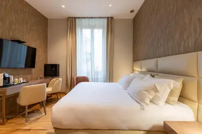 a hotel room with a large white bed and a desk at Residenza Pierret in Rome