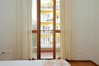 a bedroom with a bed and a large window at Monteverde family apartment in Rome