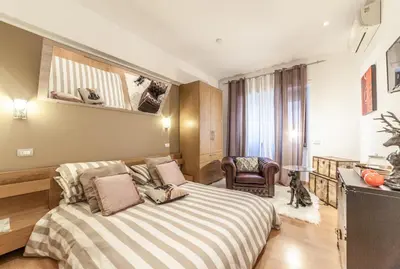 a bedroom with a bed and a chair in a room at Ubaldi Luxury Rooms in Rome
