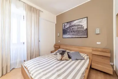 a bedroom with a bed with a striped blanket at Ubaldi Luxury Rooms in Rome