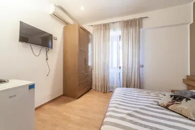 a small bedroom with a bed and a mirror at Ubaldi Luxury Rooms in Rome
