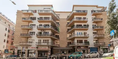 a tall building with balconies on a city street at Ubaldi Luxury Rooms in Rome