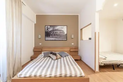 a bedroom with a bed with a striped mattress at Ubaldi Luxury Rooms in Rome