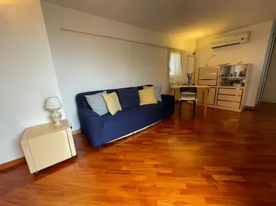 a living room with a blue couch and a wooden floor at Trastevere Lenci House in Rome
