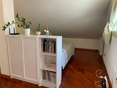 a bedroom with a white book shelf with books at Trastevere Lenci House in Rome