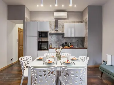 a kitchen and dining room with a white table and chairs at The Best Rent - Three-bedroom apartment near Piazza Barberini in Rome