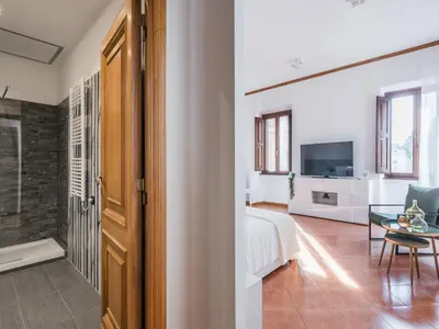 a bedroom with a bed and a living room with a table at The Best Rent - Three-bedroom apartment near Piazza Barberini in Rome
