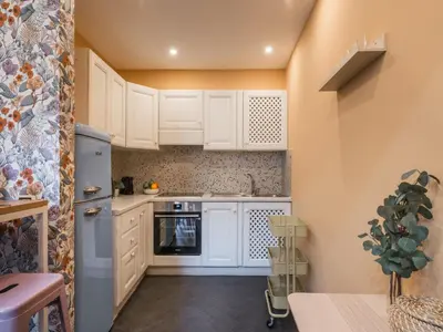 a kitchen with white cabinets and a refrigerator at The Best Rent - Colorful loft in Trastevere area in Rome