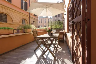 a table and chairs on a balcony with an umbrella at Domus Rinascimento (Piazza Navona) in Rome
