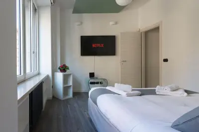 two beds in a room with a tv on the wall at Domus Rinascimento (Piazza Navona) in Rome