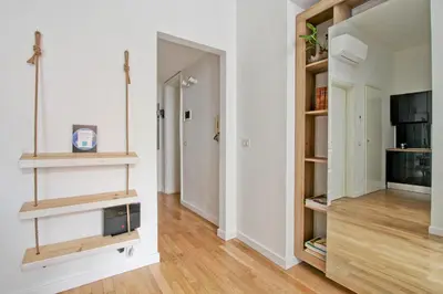 a living room with white walls and wooden shelves at Saturno in Trevi in Rome