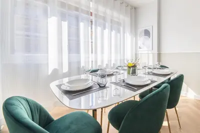 a dining room with a glass table and green chairs at Vatican City Apartment in Rome