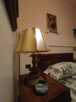 a lamp on a table next to a bed at Gay House Roma - Only Gay in Rome