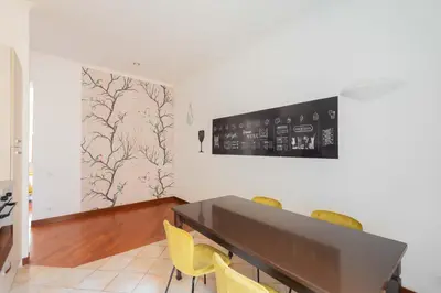 a dining room with a table and yellow chairs at AppleMoon2.0 in Rome