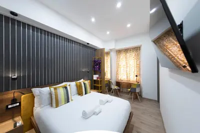 a bedroom with a white bed and a table at Cola Suites Apartments in Rome